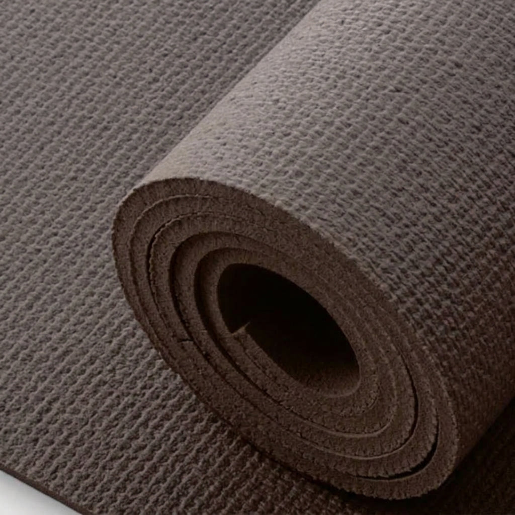 A close-up of a rolled exercise or yoga mat in a dark brown color, showing its textured surface and layered construction.