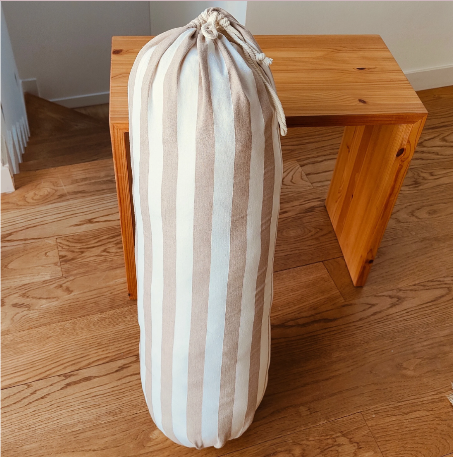 beige and brown yoga bolster on wood floor