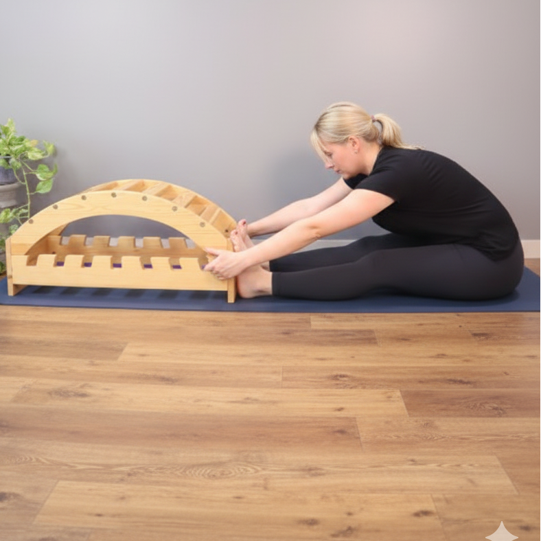 Person using a wooden yoga forward bender on a mat with a neutral background