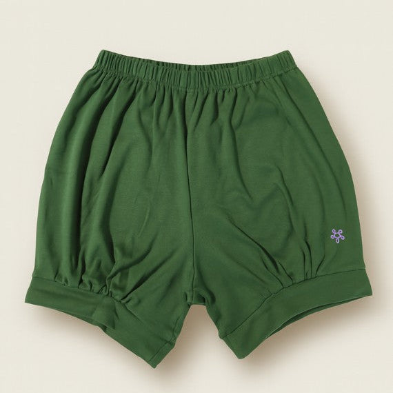 Green iyengar yoga shorts with a small logo on a beige background