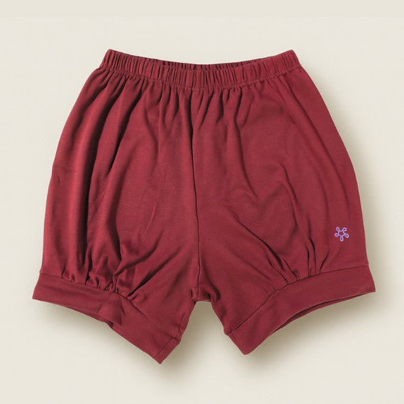 maroon yoga shorts with a small purple flower design on a beige background