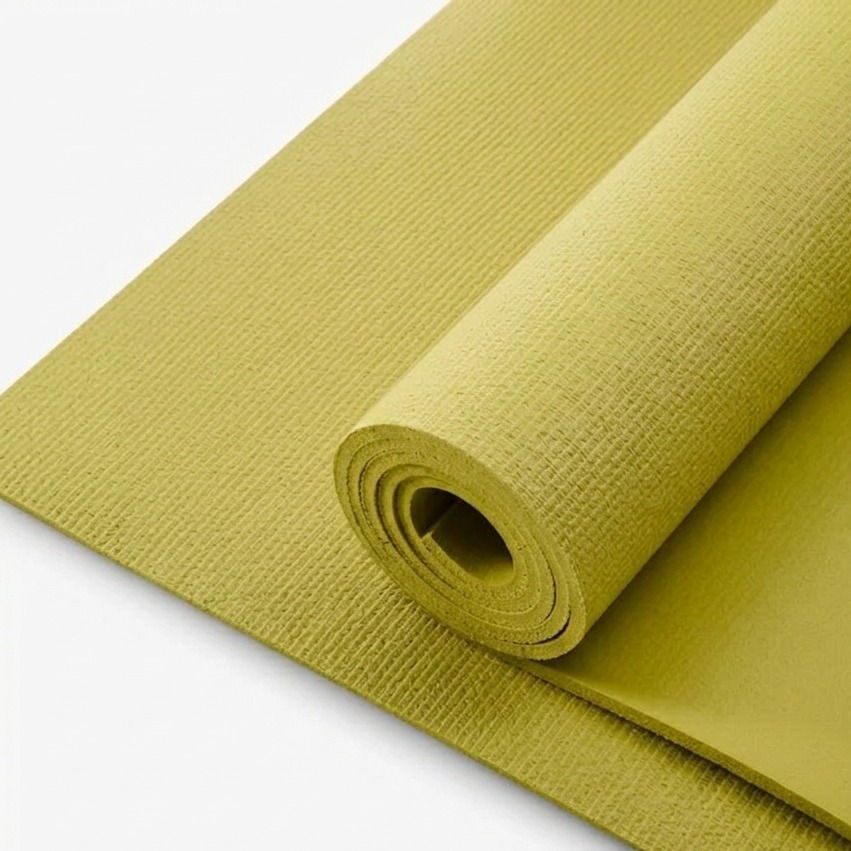 Green yoga mat rolled up on a white background