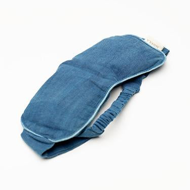 A blue denim sleep mask with a matching elastic strap, photographed on a clean white background.