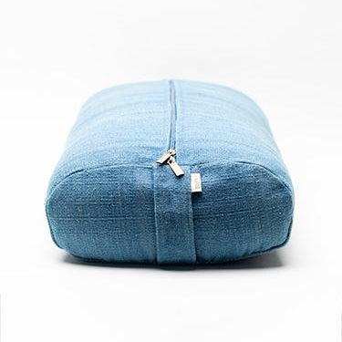 A blue zippered cotton yoga bolster with a textured fabric cover, shown on a clean white background.