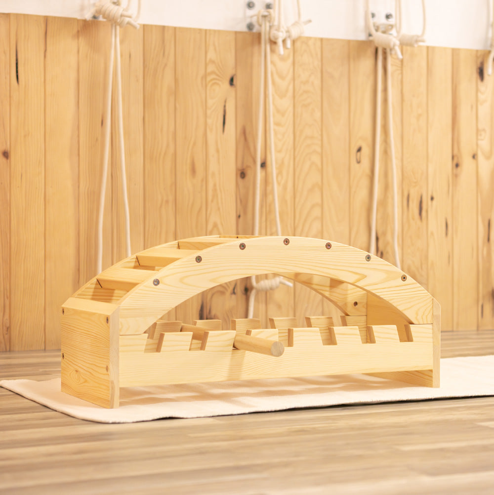 Wooden iyengar yoga viparita bench on a wooden floor with a wooden wall background